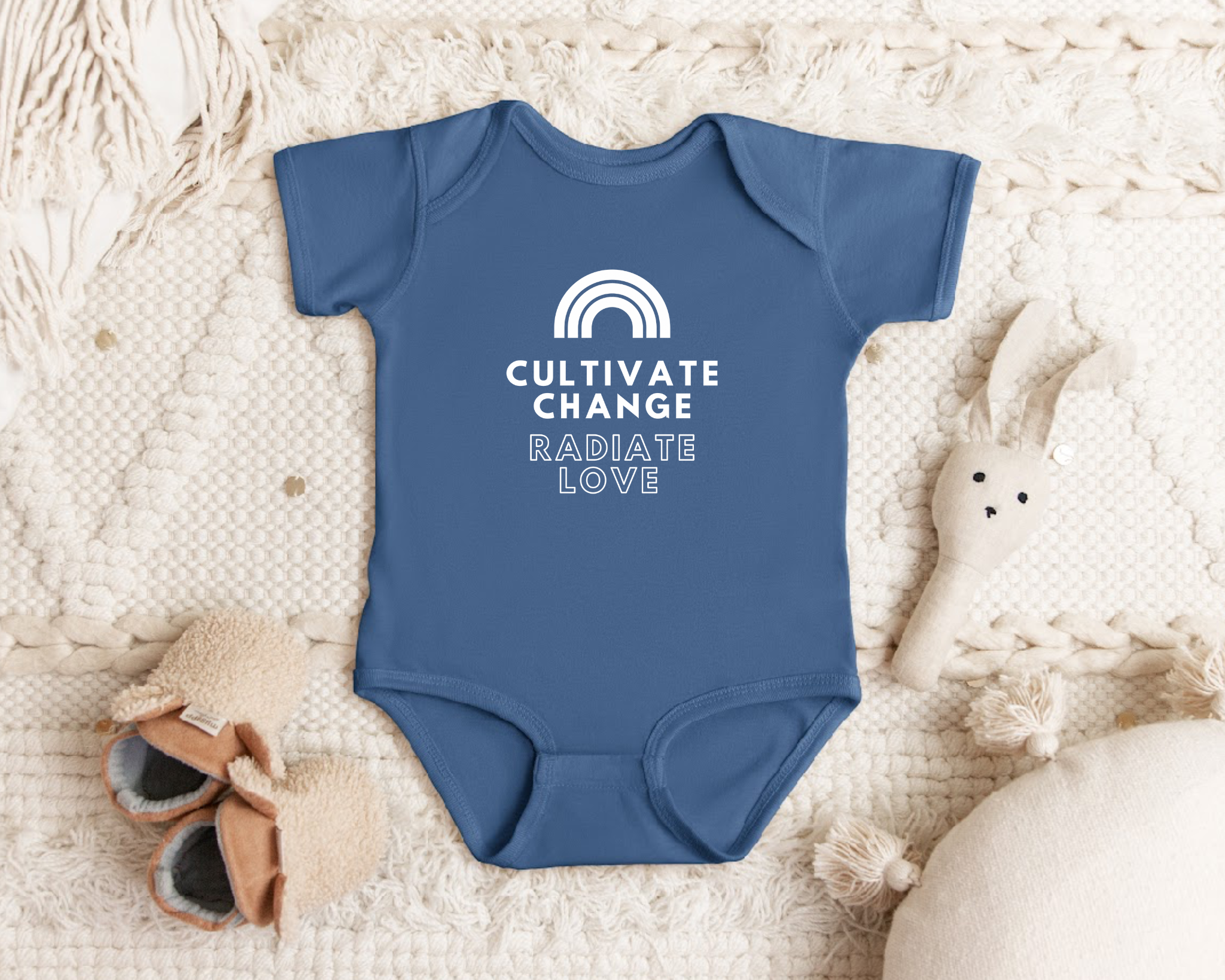 "Cultivate Change" infant onesie by Say Hello Threads, featuring a rainbow design promoting growth and positivity.