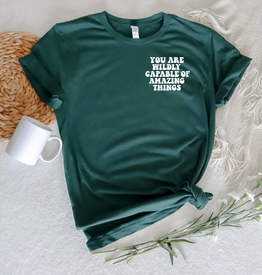 say hello threads shirt with the words you are wildly capable of amazing things on the pocket and on the back of the shirt in large font. 