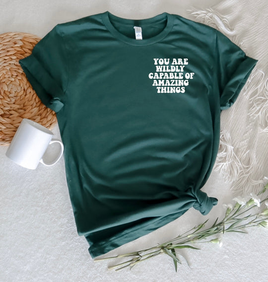 say hello threads shirt with the words you are wildly capable of amazing things on the pocket and on the back of the shirt in large font. 
